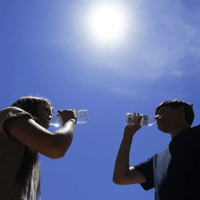 Tony Berastegui Jr., right, and his sister Giselle Berastegui drink water, Monday, July 17, 2023, in Phoenix. Ross D. Franklin / AP