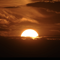 The setting sun illuminates the clouds over the Rocky Mountains after a third straight day of record-breaking heat Sunday, July 14, 2024, in Denver (AP Photo/David Zalubowski)