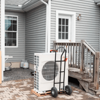 Photo of a heat pump in front of a house. (Tristan Spinski for The Washington Post/Getty Images)