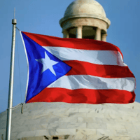 The Puerto Rican flag flies in front of the Capitol building in San Juan, Puerto Rico
